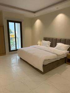 a bedroom with a large bed with a large window at شقة فاخرة مودرن in Al Kharj