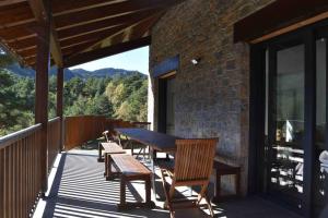 a wooden table and chairs on a deck at Cal Manubens in Castellar del Riu