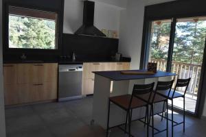 a kitchen with a blue table and chairs in a room at Cal Manubens in Castellar del Riu