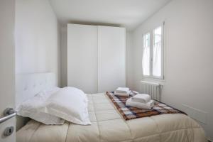 a white bedroom with a bed with towels on it at Serenity - Sweet Dreams in Florence in Florence