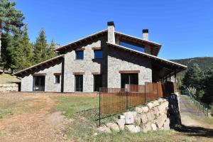 una casa de piedra con una valla delante de ella en Cal Manubens, en Castellar del Riu