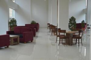 una sala de espera con sillas y mesas en un edificio en Win Grand Hotel, en Kaliabang-tengah