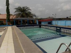 basen w ośrodku z budynkiem i palmami w obiekcie ROYAL PARAGON HOTEL w mieście Egbelu