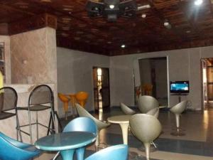 Pokój z krzesłami, stołami i telewizorem w obiekcie ROYAL PARAGON HOTEL w mieście Egbelu