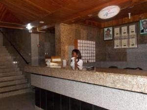 Kobieta siedząca przy ladzie w restauracji w obiekcie ROYAL PARAGON HOTEL w mieście Egbelu