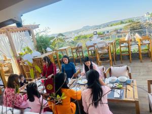 Ngon Avatar Hotel في بلاي كو: مجموعة من النساء يجلسن على طاولة في الفناء