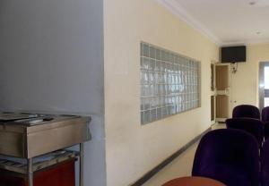 ein Wartezimmer mit lila Stühlen und einem Fenster in der Unterkunft GADE PLACE HOTEL in Alakohia