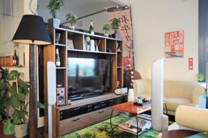sala de estar con TV en un centro de entretenimiento en B&B Yado Kitakai, en Kikonai