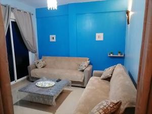 a living room with blue walls and a couch and a table at TANGER beach in Tangier