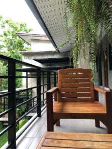 a wooden bench sitting on top of a balcony at palmhouse in Mae Hong Son