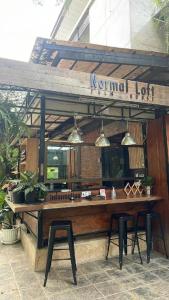 un restaurante con una mesa de madera y dos taburetes en palmhouse en Mae Hong Son