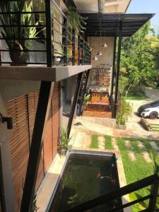 vistas a una casa con un koi en la piscina en palmhouse en Mae Hong Son