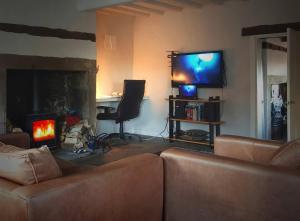 ein Wohnzimmer mit Couch und Kamin in der Unterkunft Sculpture Park Cottage in Penistone