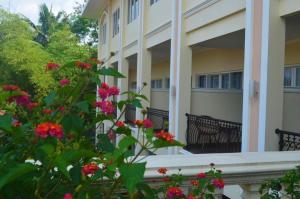 a balcony of a building with pink flowers at Nina Hotel in Salatiga