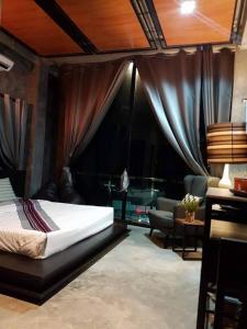 1 dormitorio con 1 cama y sala de estar en Theloft boutique nakhonpanom, en Ban Noi Pho Kham