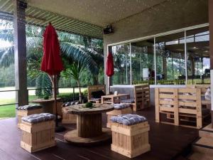 a patio with a table and chairs and windows at Kabinburi Sport Club - KBSC in Ban Nong Kha