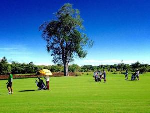 un grupo de personas jugando al golf en un campo en Kabinburi Sport Club - KBSC, en Ban Nong Kha