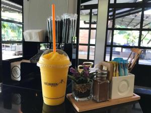 a drink on a table with an orange drink at Kabinburi Sport Club - KBSC in Ban Nong Kha