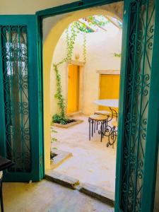 una porta aperta su un patio con tavolo e sedie di Dar Kenza a Djerba