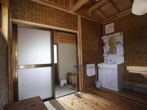 a room with a kitchen with a door and a sink at Yufuin Tsukahara Villa ERINA in Yufuin