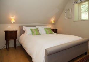 een slaapkamer met een groot wit bed en 2 groene kussens bij Glebe Farm B&B in Kingsbridge