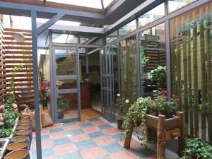 Pankun Business Hotel في كونمينغ: بيت زجاجي به نباتات خزف ومقعد خشبي