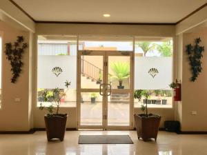 a lobby with a glass door with potted plants at Victoria Palms Hotel in Suva