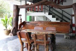 a wooden table and chairs in a room with stairs at Tantawan Place in Roi Et