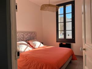 a bedroom with a bed and a window at Quai du Félibre in LʼIsle-sur-la-Sorgue