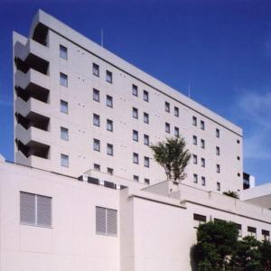 um grande edifício branco com uma árvore em cima em Hotel Grand Shinonome em Tsukuba