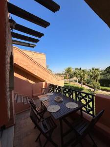 eine Terrasse mit einem Tisch und Stühlen auf dem Balkon in der Unterkunft Cozy apartment with roof top in Marrakesch