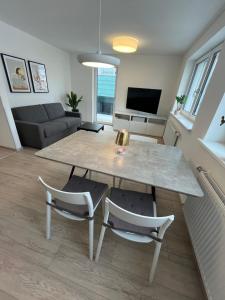 ein Wohnzimmer mit einem Tisch und 2 Stühlen in der Unterkunft City Living Bischofshofen - neue Stadtwohnung in Bischofshofen