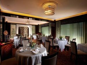 a dining room with white tables and chairs at Tongxiang Inspirock Hotel in Jiaxing