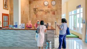 Royal Hill Satun Hotel في Ban Pak Ba Ra: مجموعة نساء واقفات عند كاونتر في محل