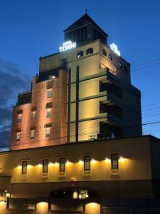 富山市にあるHotel Torni ホテル トルニのネオンの看板が立つ建物