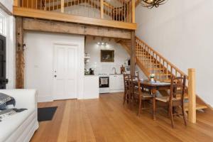 eine Küche und ein Wohnzimmer mit einem Tisch und einer Treppe in der Unterkunft Harland Rise Chapel Circa 1830 in Evandale