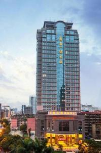 a tall building with a sign on it in a city at Vienna International Hotel Nanning Railway Station Mingxiu Road Metro Station in Nanning