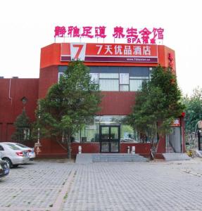 un bâtiment rouge avec un panneau en haut dans l'établissement 7 Days Premium Beijing Dabaotai Metro Station Luhua Road, à Pékin