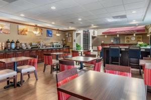 a restaurant with tables and chairs and a bar at Comfort Inn & Suites Suwanee - Sugarloaf in Suwanee