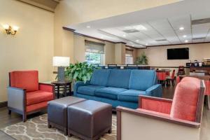 a living room with a blue couch and chairs at Comfort Inn & Suites Suwanee - Sugarloaf in Suwanee