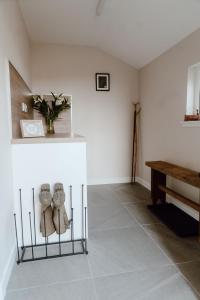 a room with a table and some shoes on a shelf at Cleod9 -Croft house at 9 Garenin in Carloway