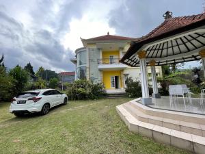 a white car parked in front of a house at Royal Maharani Bedugul in Tabanan
