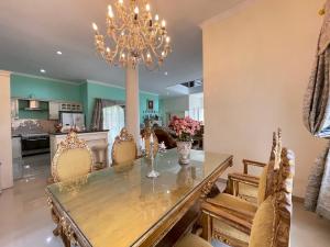 a dining room with a table and chairs and a chandelier at Royal Maharani Bedugul in Tabanan
