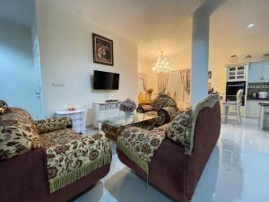 a living room with two couches and a tv at Royal Maharani Bedugul in Tabanan