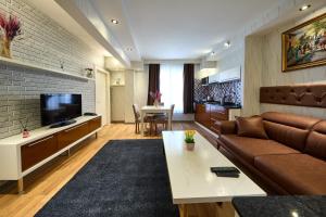 a living room with a couch and a television at By Aydın Suites in Istanbul