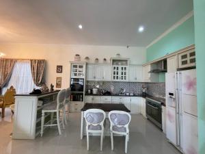 a kitchen with white cabinets and a table and chairs at Royal Maharani Bedugul in Tabanan +6 photos