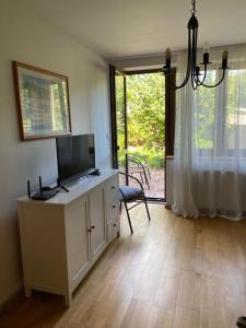 een woonkamer met een tv en een groot raam bij Na Husovce in Teplice