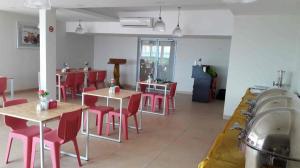 a restaurant with red chairs and tables and a kitchen at Karimun City Hotel in Tanjung Balai Karimun +22 photos