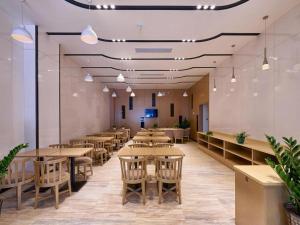 Un restaurante con mesas y sillas de madera y luces. en Lavande Hotel Jinan Quancheng Road Baotu Spring Branch, en Jinan 191 fotos más
