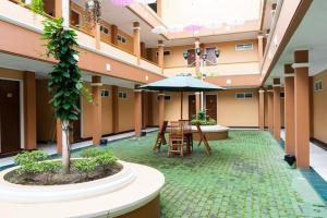 a courtyard with a table and an umbrella in a building at Hotel Griya Tirta in Pangkalpinang